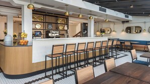 A modern restaurant with a bar area, seating, and a display of plates.