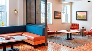A modern interior with a sectional sofa, a round table, and a large window.