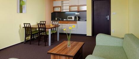 Un espacio habitable compacto con comedor, kitchenette y sofá.