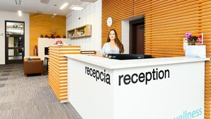 A reception desk with a sign reading "reception" and "wellness" in a modern office setting. - Apartmánový dom Família Smokovec (Vysoké Tatry)