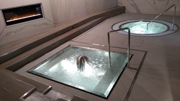 A spa area with a hot tub and a rectangular soaking tub with a metal ladder. - Apartmánový dom Família Smokovec (Vysoké Tatry)