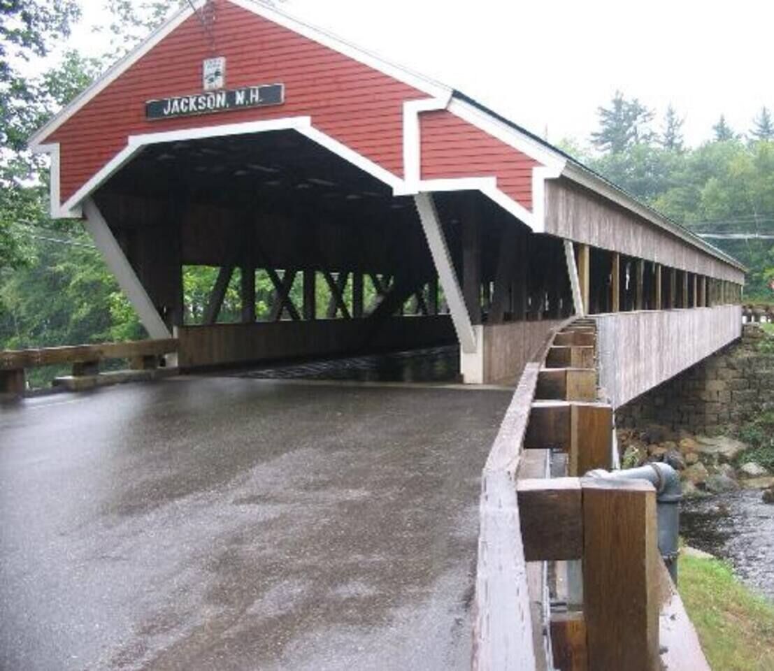 A covered bridge with a sign reading "Jackson, N.H."