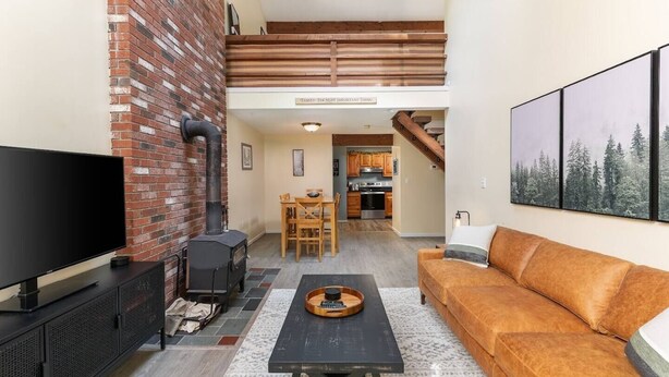 A living room with a fireplace, a television, a sofa, and a dining area with a table and chairs. - Great place to stay for multiple families all year (Bartlett)
