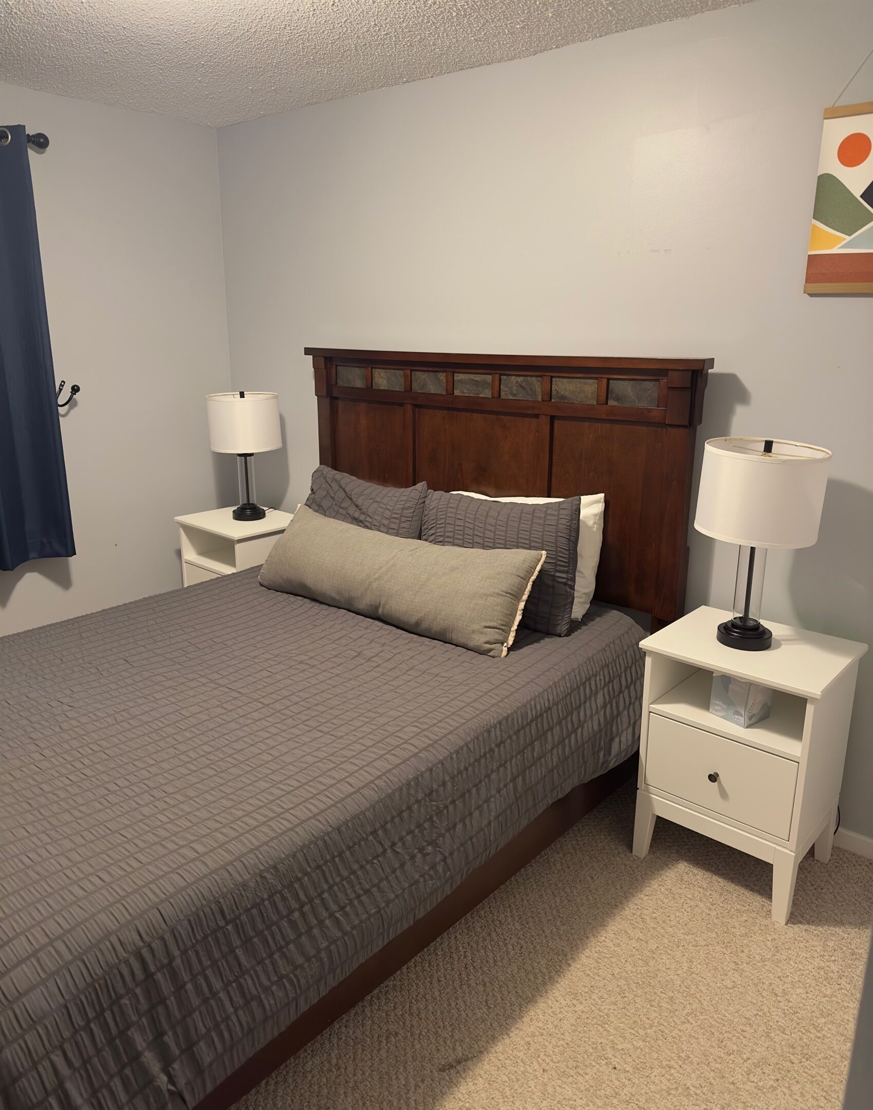 Ein Schlafzimmer mit einem großen Bett, zwei Nachttischen und einer Kopfteil.