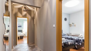 Habitació d'hotel amb un disseny modern, que destaca un llit gran amb un sobrellit estampat, una taula de nit petita i un rellotge fixat a la paret.