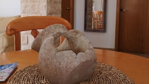 A round wooden table with a woven placemat, a stone sculpture, and a magazine on it. - Apt. Santa in the old town, unsoperable views and just 3 minutes from the beach (Alicante)