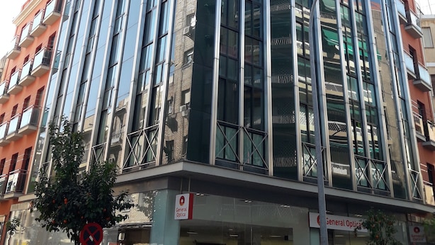 Un immeuble à plusieurs étages doté de grandes fenêtres et de balcons.