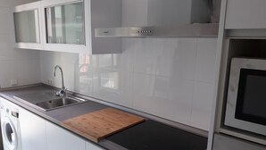 Une cuisine moderne dotée d’un évier en acier inoxydable, d’un four encastré et d’un four à micro-ondes.
