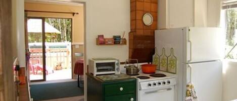 A compact kitchen with a stove, oven, and a small countertop with a toaster.