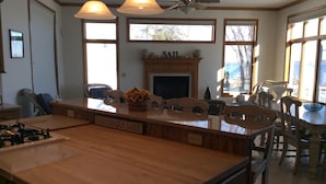 A kitchen with a central island, wooden cabinets, a gas stove, and a fireplace.