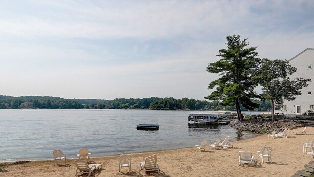 A lakeside view with beach chairs and a dock. - The Docksider - Couples & Young Families - Lakefront! (Wisconsin Dells)