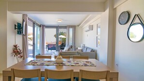 A dining area with a table, chairs, and a view of the outdoor seating area.