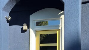 A blue building with a yellow door, a security alarm sign, and a small porch. - Beautiful ocean retreat (Morro Bay)