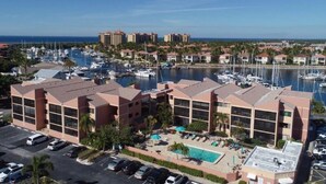 Ein Hotel mit Blick auf eine Marina, mehreren Balkonen und einem Poolbereich.