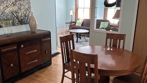 A dining area with a wooden table and chairs, a wooden cabinet, and a ceiling fan. - Quiet, Spacious Apt in the Heart of Marquette! (Marquette)