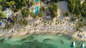 An aerial view of a resort with a large pool, multiple beach areas with sun loungers, and clear turquoise waters. - Beautiful sea view Golf Villa in Casa de Campo (La Romana)