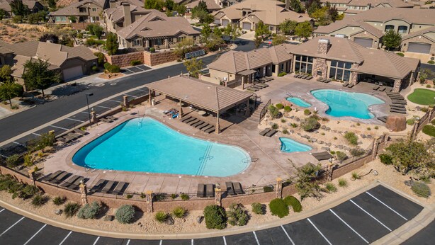 A residential area with multiple houses, a swimming pool, and a parking lot.