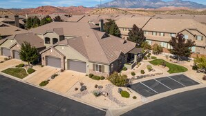 A residential area with multiple houses, each with a garage, surrounded by landscaped gardens and a parking area.