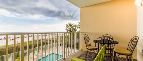 A balcony with a pool, chairs, and a table.