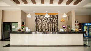 A reception area with a modern design, featuring a reception desk, pendant lighting, and a decorative wall with a tree motif. - MaiHom Villa (Nakhon Sawan)