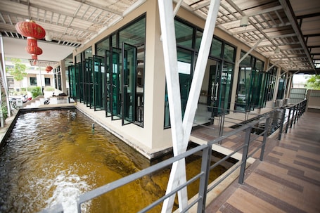 A modern building with a long corridor, large windows, and a water feature.