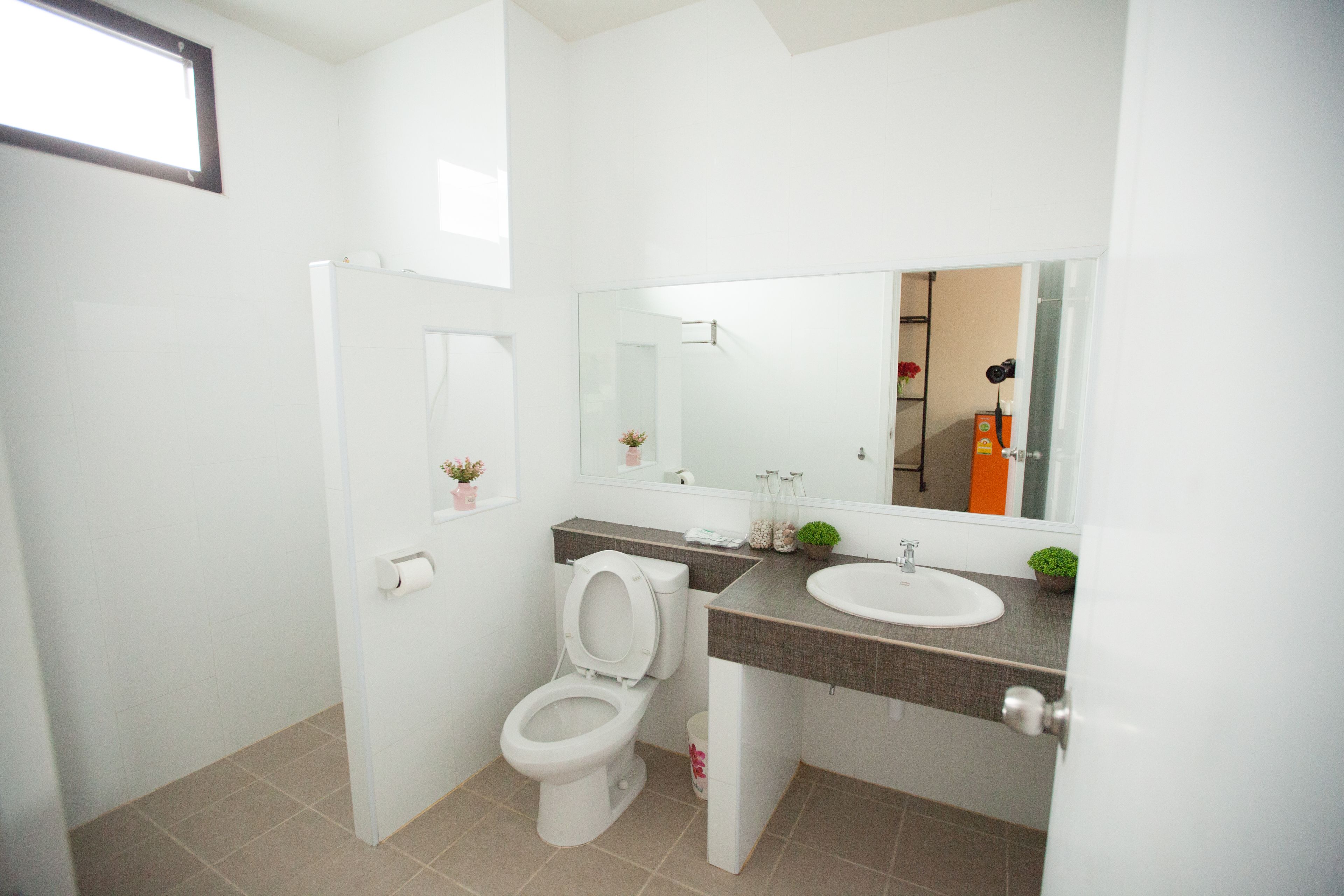 A modern bathroom with a toilet, sink, and mirror.