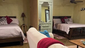 A hotel room with two beds, a sofa, a wooden coffee table, and a mirror. - Perfect for work or fun! 1 NIGHT RENTAL AVAILABLE! (College Station)