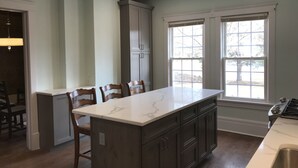 A kitchen with a central island, dark cabinets, and a window providing natural light.