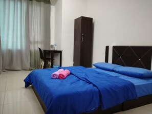 Relax in a cozy space with a neatly made bed, desk, and wardrobe.
