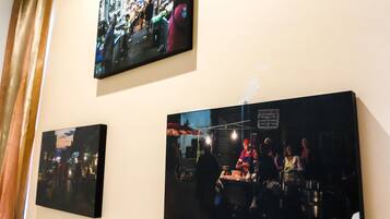 A wall with three framed photographs depicting busy market scenes.