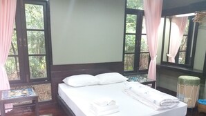 A neatly made bed with white linens and pillows, a wooden headboard, and a small table with a tiled top beside the bed. - 339 Hotels & Resort (Nakhon Ratchasima)