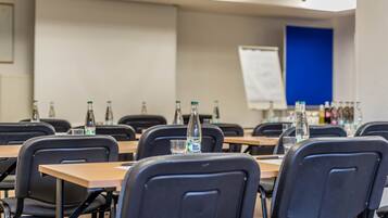 A conference room with tables, chairs, and water bottles.