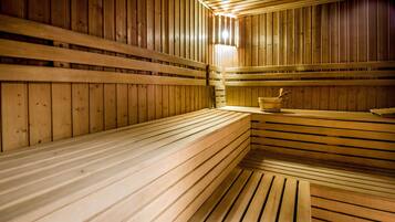 A sauna with wooden benches and a wooden tub.