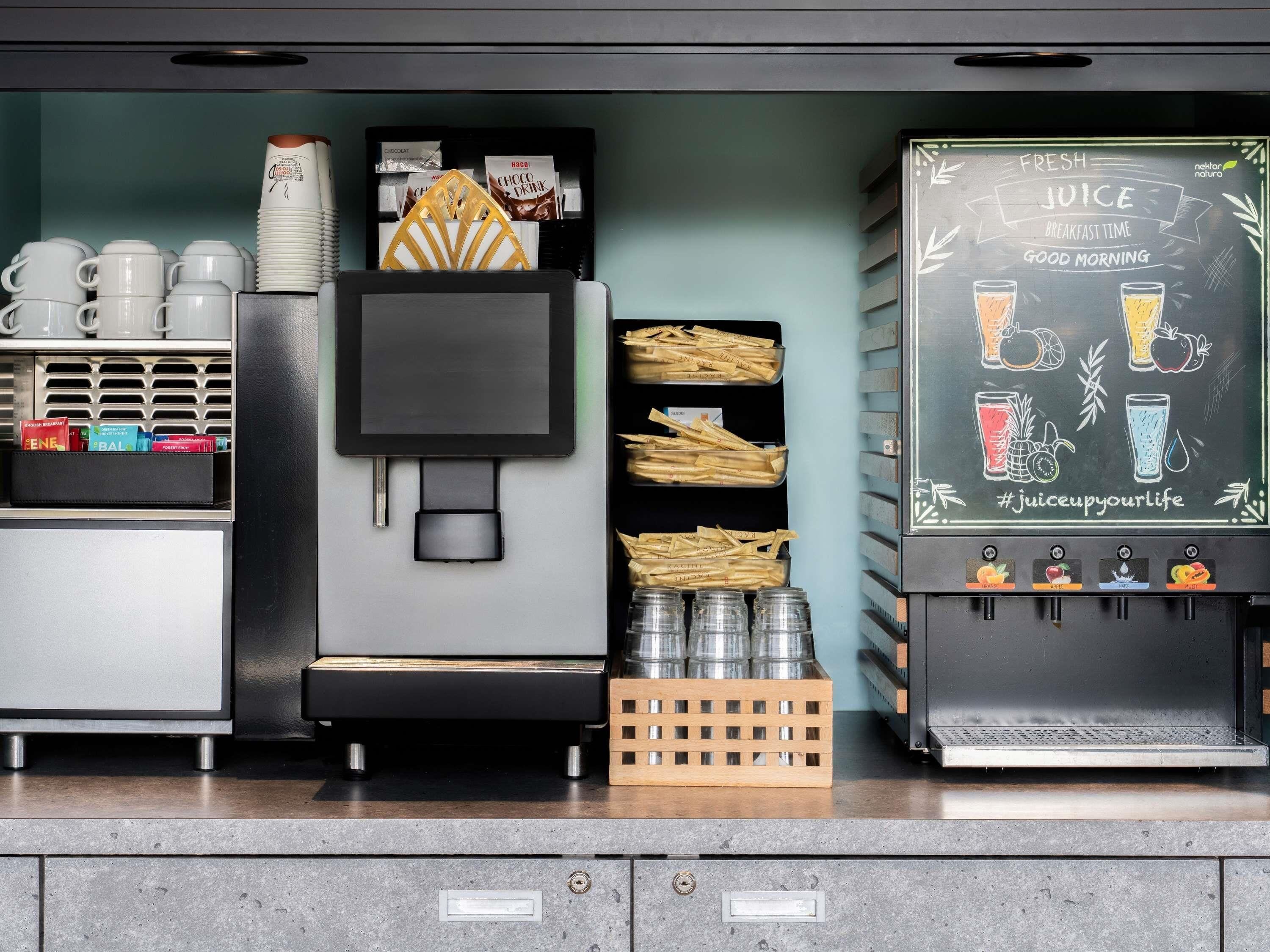 A coffee machine with a chalkboard menu, a coffee press, and a milk frother.