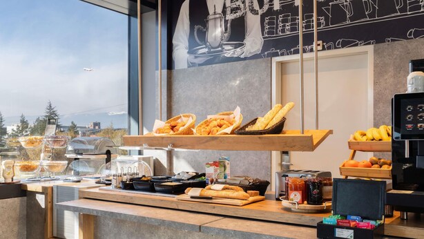 Buffet de café da manhã com pães, doces e frutas.