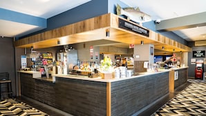 A hotel bar with a wooden counter, a fish decoration, and a patterned floor. - Swansea Hotel (Swansea)