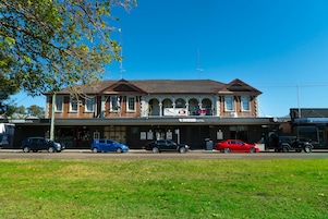 A hotel with a classic architectural style, featuring a central arched entrance and multiple windows.