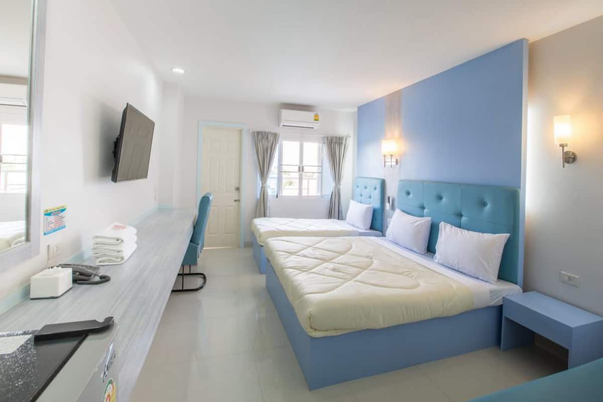 A hotel room with a bed, bedside tables, a desk with a chair, a TV mounted on the wall, and a window with curtains.