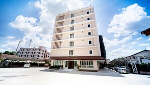 A multi-story hotel with a flat facade, large windows, and a covered entrance. - P.A. Thani Hotel (Nakhon Sawan)