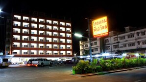 A multi-story hotel with illuminated windows and a neon sign advertising the hotel. - P.A. Ville Hotel (Nakhon Sawan)