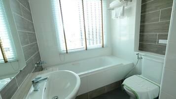 Un baño moderno con bañera, lavamanos e inodoro.