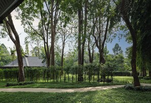 Un sendero atraviesa un jardín con árboles y un edificio de techo a tejas.