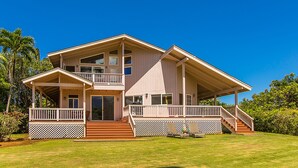 A two-story house with a covered porch, a staircase leading to the upper level, and a well-maintained lawn. - Waterfalls, Palm Trees, and Hanalei Bay,  Short walk to beaches and resorts (Princeville)
