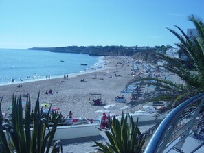 A beach with people, umbrellas, and boats. - Confortable T1 in promenade of the sea and beach, sea view, Armação Pêra Algarve (Armação de Pêra)