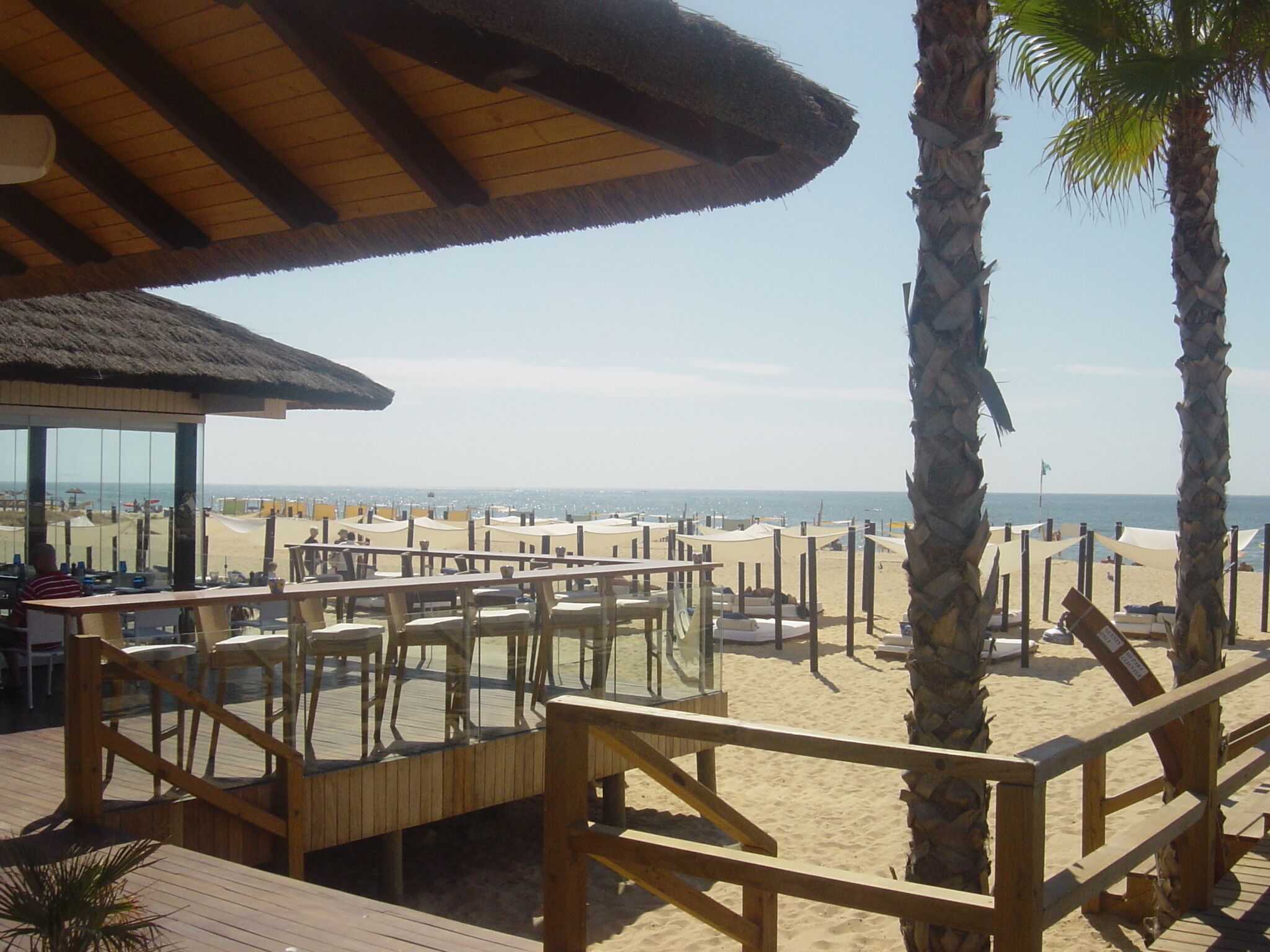A beachside restaurant with outdoor seating overlooking the ocean.