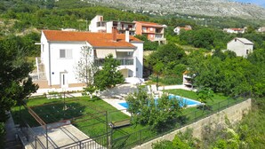 Un quartiere residenziale con case, una piscina e montagne sullo sfondo.