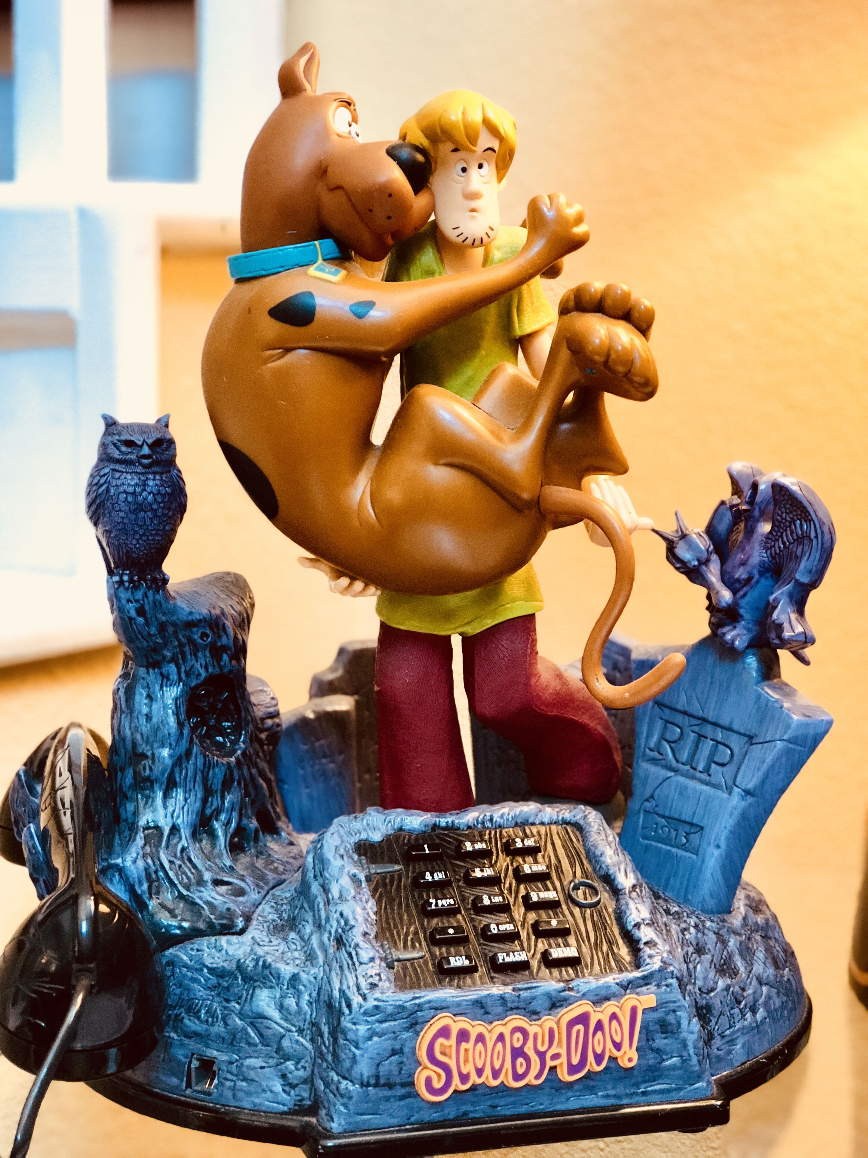 A Scooby-Doo figurine with Scooby and a dog, surrounded by a tombstone and an owl.