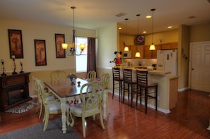 Enjoy meals in the dining area with a wooden table and four chairs, surrounded by framed artwork.