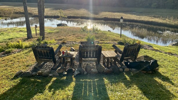 A lakeside seating area with Adirondack chairs and a picnic table, surrounded by rocks and grass. - Tall Pines Retreat, Somesville|Mt. Desert. 15 min to Bar Harbor, 5 to Acadia (Mt Desert)