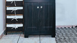 A bathroom with a dark wooden cabinet, a towel rack, and a mirror on the wall. - Casa Katrina #1 (Sayulita)